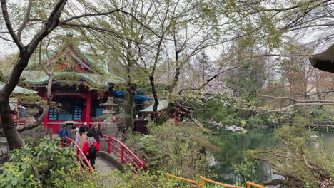People-cross-a-bridge-to-Inokashira-Benzaiten-Shrine-in-front-of-a-lake