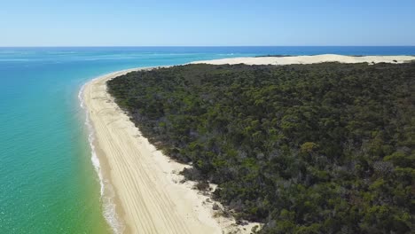 Drone-footage-of-long-white-sandy-beach-on-a-calm-sunny-day-at-the-Sandy-Cape,-Fraser-Island,-Queensland,-Australia