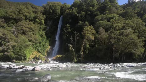 Weitwinkelaufnahme-Eines-Flusses,-Der-Vor-Einem-Wasserfall-In-Einem-Dichten-Einheimischen-Wald-Fließt