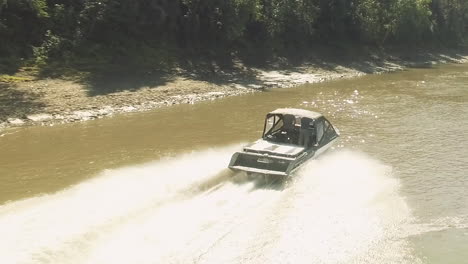 A-drone-chases-a-speedboat-on-a-shallow-winding-section-of-river
