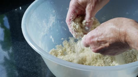 Woman-mixes-flour-and-butter-in-a-large-mixing-bowl-to-make-pastry