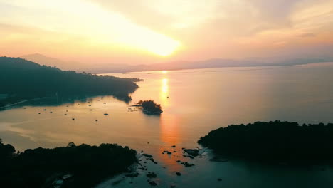 Der-Sonnenaufgang-Während-Der-Goldenen-Stunde-über-Einer-Bucht-Mit-Ein-Paar-Booten-In-Langkawi,-Malaysia