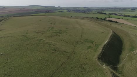 Rotating-aerial-around-the-famous-Iron-age-hill-fort-of-Maiden-Castle,-Near-Dorchester,-Dorset