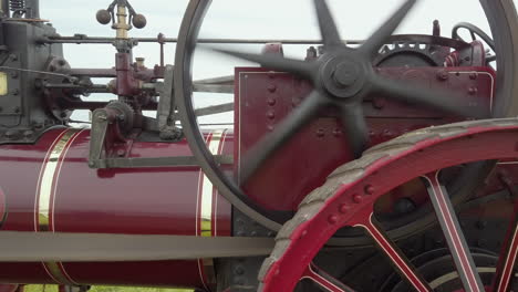 Close-up-of-the-side-of-a-red-vintage-traction-engine-in-operation