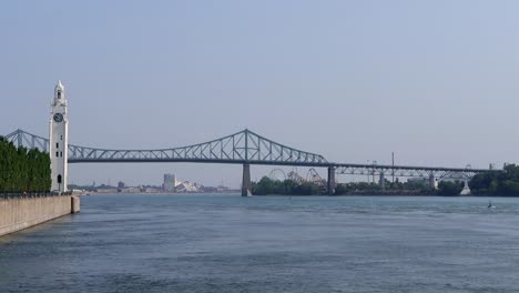 Mit-Blick-Auf-Den-Uhrturm-Und-Die-Jacques-Cartier-Brücke-Im-Sankt-Lorenz-Fluss-In-Montreal,-Quebec