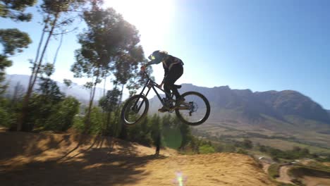 Extreme-mountain-biker-doing-a-backflip-during-Darkfest-in-Stellenbosch,-South-Africa