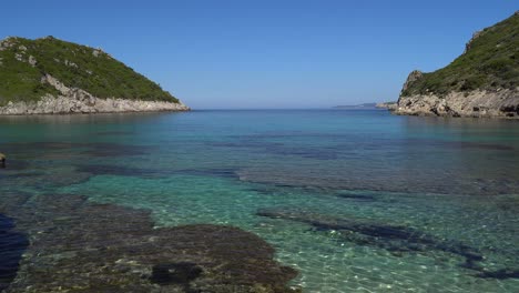 Smooth-panning-shot-of-the-crystal-clear-waters-of-Porto-Timoni-beach-on-the-Island-of-Corfu
