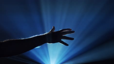 Hand-reaches-out-into-ghostly-light-beams