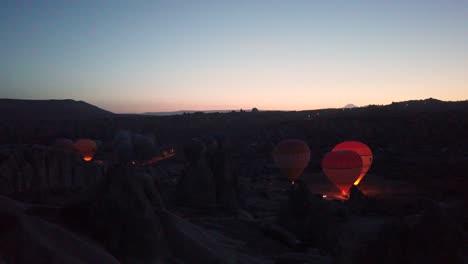 Colourful-hot-air-balloons-prepare-for-take-off-at-dawn-in-Cappadocia,-Turkey