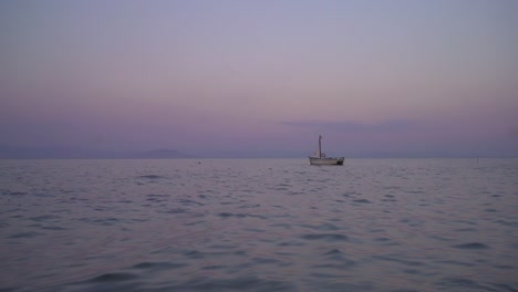 Kleines-Segelboot,-Das-Bei-Sonnenuntergang-Im-Meer-Schwimmt