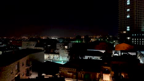 Jerusalem-city-lights-reveal-at-night,-aerial-shot