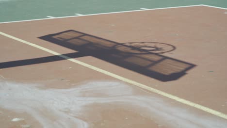 Shadow-of-a-basketball-board-on-used-outdoor-court