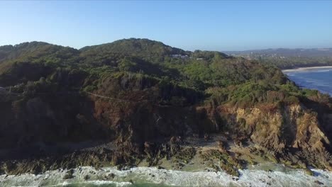 Aerial-drone-tracking-shot-of-Cape-Byron-cliffs-with-waves-crashing