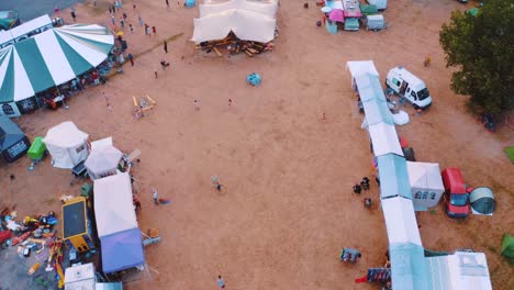 Colorful-Tents-Set-Up-On-A-Campsite-Near-The-Forest---aerial-shot