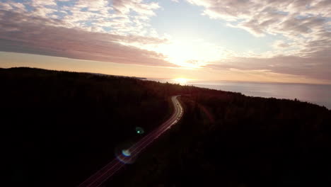 Aerial:-Car-Driving-Along-Empty-Country-Road-Into-Golden-Summer-Sunset