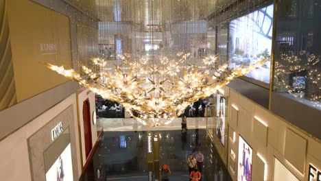 Tilting-upward-view-from-lower-level-Icon-Siam-luxury-shopping-mall-to-highly-decorative-golden-hanging-chandelier