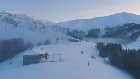 Luftaufnahme,-Drohnenaufnahme-Des-Sonnenuntergangs-über-Dem-Botev-Gipfel-Und-Der-Pleven-Hütte-Im-Balkangebirge,-An-Einem-Sonnigen-Wintertag-Im-Morgengrauen-Im-Zentralbalkan-Nationalpark,-Bulgarien