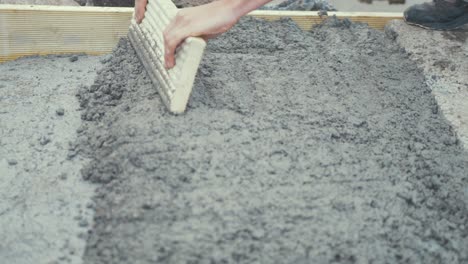 Compacting-working-rough-cement-with-wooden-board-CLOSE-UP-SLOW-MOTION