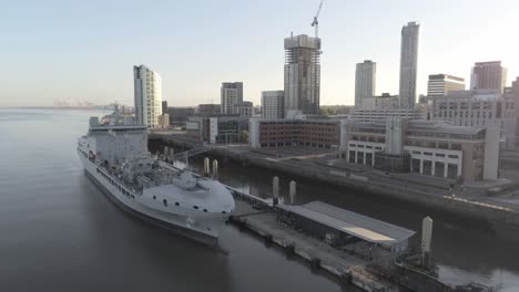 Liverpool-waterfront-aerial-view-royal-navy-military-ship-sunrise-high-rise-buildings-skyline-left-orbit