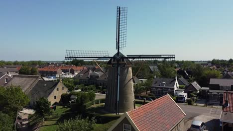 Drohnenaufnahmen-Einer-Holländischen-Windmühle-In-Einem-Kleinen-Dorf,-Die-Getreide-Zu-Mehl-Mahlt