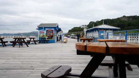 Llandudno-seaside-resort-town-pier-tourists-corona-virus-social-distancing-on-boardwalk-dolly-right