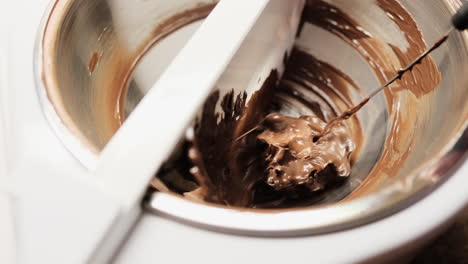 Close-up-of-melted-chocolate-being-stirred-in-tempering-machine