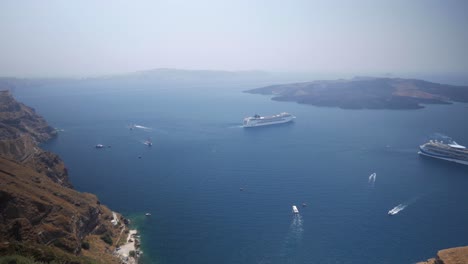 Weitwinkelaufnahme-Der-Aussicht-Von-Thira-Auf-Die-Stadt-Santorin-In-Griechenland-Mit-Vielen-Booten,-Fähren-Und-Inseln-Mit-Den-Klippen-Der-Hauptinsel-Santorin