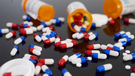 Many-prescription-pills,-drugs-and-antidepressants-spilling-in-slow-motion-from-an-orange-pharmacy-medicine-bottle