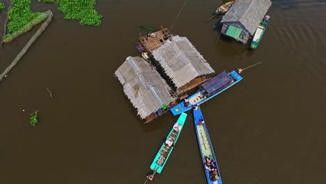 Locals-Merchants-Going-About-Everyday-Life-In-The-Floating-Village-Of-Kompong-Kleang-In-Cambodia---aerial-shot