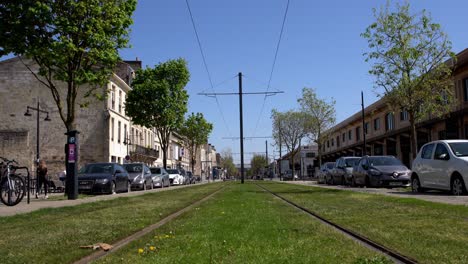 Trolley-tram-tracks-near-Cité-du-Vin-during-the-COVID-19-pandemic-with-parked-cars,-Locked-low-angle-shot