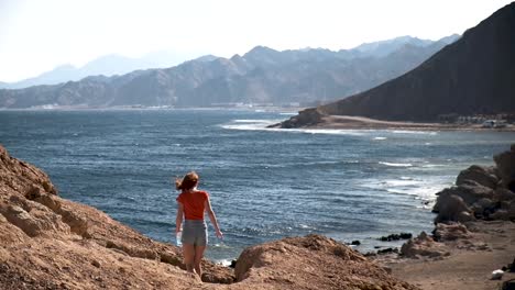 Girl-walking-down-from-the-viewpoint-looking-over-the-Blue-Hole-in-Dahab-at-the-Red-Sea-in-Egypt