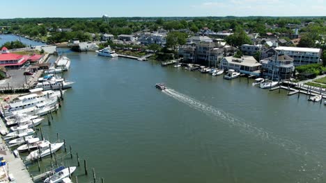 AERIAL-SLOW-MOTION-Small-Boat-Cruising-Down-Lewes-Canal,-Delaware