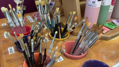 Picking-a-paint-brush-at-Color-Me-Mine-Art-and-Pottery-studio-in-Saratoga,-California