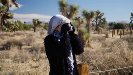 Eine-Erwachsene-Fotografin,-Die-Mit-Ihrer-Altmodischen-Filmkamera-Und-Ihrem-Objektiv-In-Einer-Wüstenlandschaft-Fotografiert