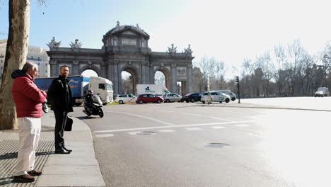 Puerta-del-Alcála-,-Plaza-de-la-Independencia,-traffic-and-pedestrians-in-slow-motion,-copy-space