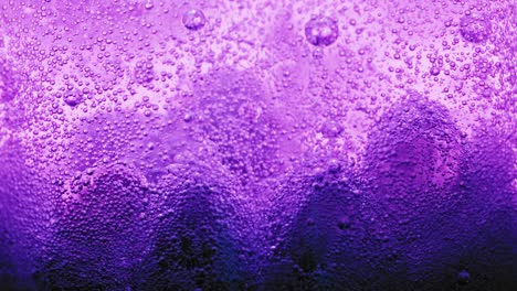 macro-shot-of-big-violet-bubbles-on-ground-of-water-and-many-small-bubbles-sparkling