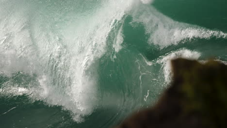 Heavy-wave-barreling-in-slow-motion-close-to-the-rocks