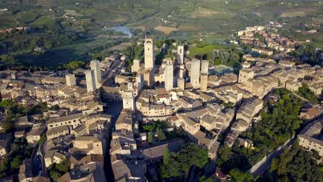 Die-Italienische-Stadt-San-Gimignano-Mit-Torre-Grossa-Und-Der-Basilika-Im-Zentrum,-Luftaufnahme-Mit-Weitem-Kreis