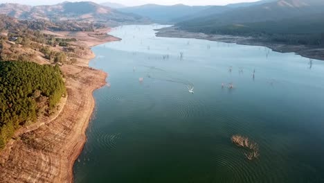 Pullback-aerial-footage-of-a-speedboat-on-Lake-Eildon,-near-Mansfield-in-central-Victoria,-Australia