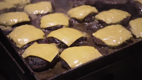 Cheeseburgers-cooking-on-a-flat-top-griddle-with-steam