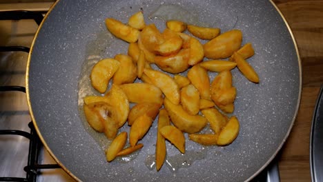 Potatoe-quarters-are-being-fryed-in-hot-pan-with-hot-and-boiling-oil-on-gas-stove