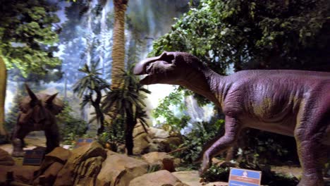 Exhibición-Jurásica-De-Dinosaurios-En-El-Parque-De-Diversiones-Sunworld-Con-Triceratops-Y-Pico-De-Pato,-Tiro-De-Mano-Izquierda