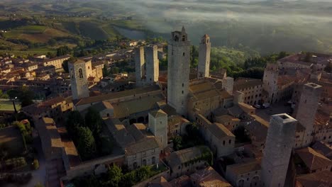 Town-of-San-Gimignano-Italy-close-up-of-Torre-Grossa-and-San-Gimignan-basilica-left,-Aerial-dolly-out-shot