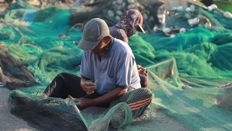 Fischer-Reparieren-Netze,-Um-Sich-Auf-Das-Fischen-Im-Meer-Vorzubereiten