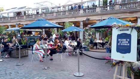 Restaurant-on-the-edge-of-Covent-Garden-with-people-sitting-out-enjoying-food-and-drink,-London,-UK