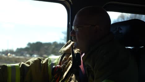 Firefighter-riding-inside-a-fire-truck-on-public-roads-viewed-from-inside-cab
