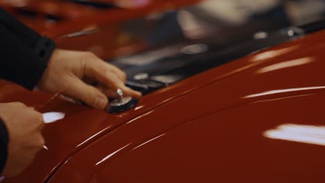 Entfernen-Des-Motorhaubenstifts-Von-Einem-Glänzend-Roten-Ford-GT-GT3-Supercar