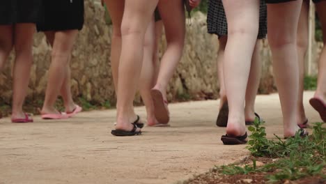 Women's-legs-walking-in-flipflops-on-a-concrete-pavement-in-Croatia,-Slow-Motion