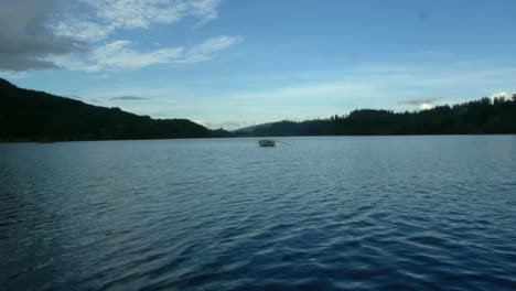 Empty-wooden-rowing-boat-on-Scottish-lake-on-summers-day