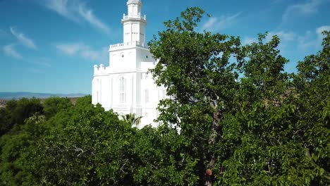 Drone-Shot-flying-upwards-revealing-the-Saint-George-Temple-behind-a-tree